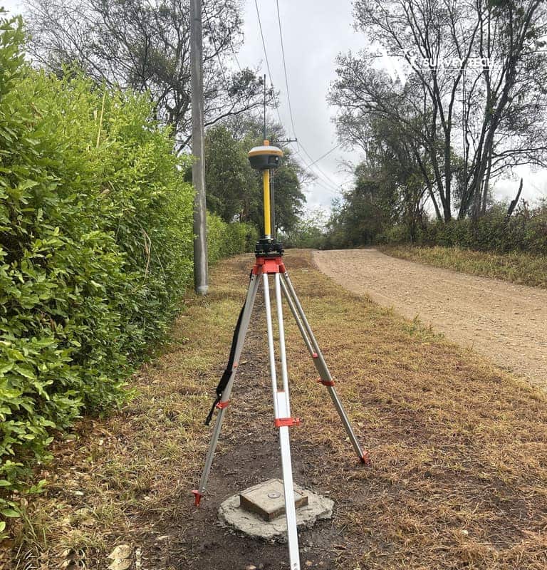 Receptor GNSS sobre trípode rastreando un vértice materializado junto a una vía destapada